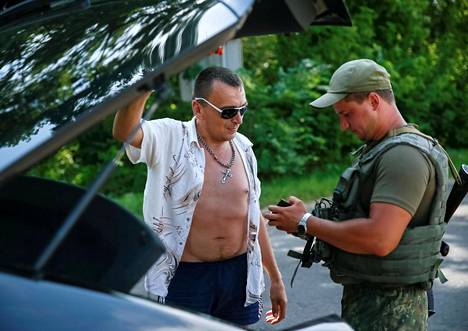 Ukrainalaissotilas tarkasti henkilöpapereita tiesululla Slovjanskissa kesäkuun lopussa.