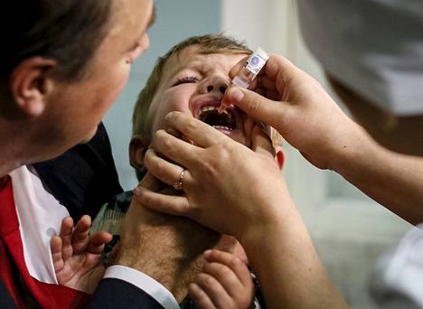 Lapsi sai poliorokotetta tippoina suuhun Kiovassa vuonna 2015.