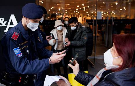 Poliisi tarkasti ostoksilla olevien koronapasseja Itävallan Wienissä marraskuussa 2021.