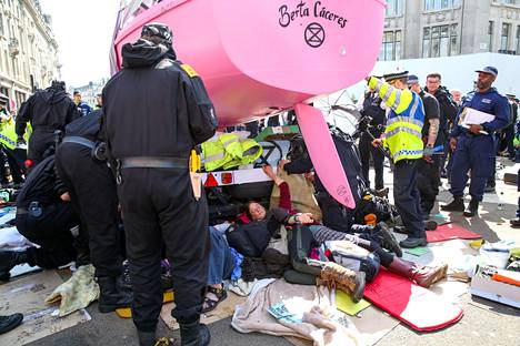 Poliisit yrittävät erottaa mielenosoittajia toisistaan Lontoossa Oxford Circusilla perjantaina.