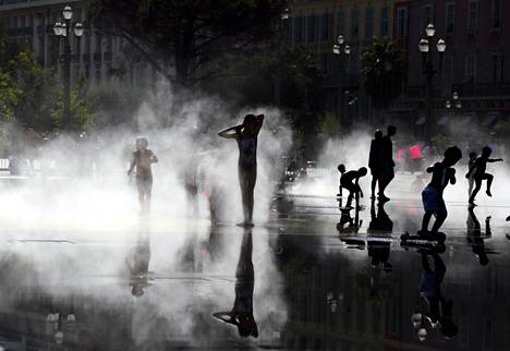 Lapset leikkivät suihkulähteessä helteisenä päivänä elokuun alussa Nizzassa Ranskassa.