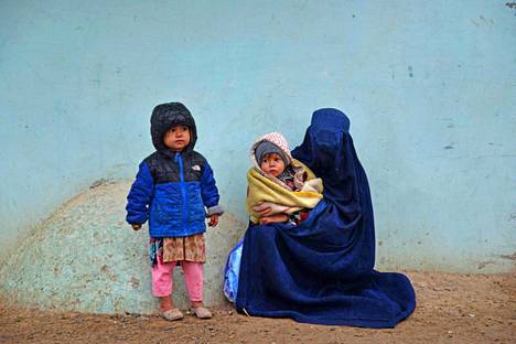Nainen istui lastensa kanssa kadulla Afganistanin Kandaharissa 18. tammikuuta.