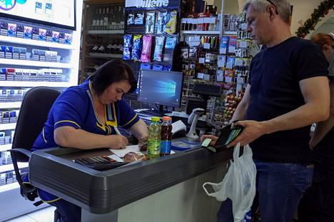 Myyjä kirjoitti käsin kuittia asiakkaan tekemistä ostoksista kaupan kirjanpitoa varten Kiovassa, Ukrainassa kesäkuussa 2017. Monet yhtiöt sulkivat tuolloin sähköisiä järjestelmiään firmoihin kohdistuneiden kyberhyökkäysten takia.