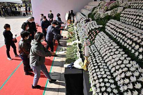 Kansalaiset toivat kukkia väentungoksessa kuolleiden yhteiselle muistoalttarille Soulin kaupungintalon edustalle maanantaina 31. lokakuuta.