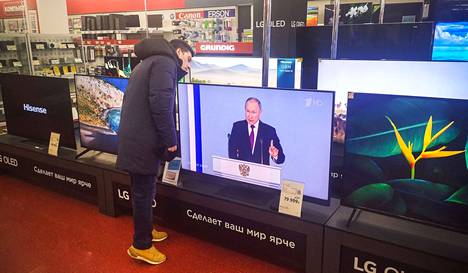 Asiakas televisioita myyvässä liikkeessä Moskovassa presidentti Putinin linjapuheen aikana tiistiana.