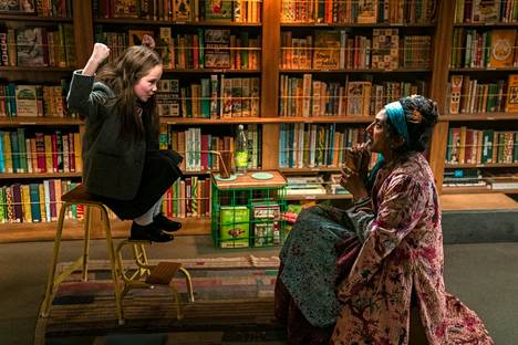 Matilda (Alisha Weir) viihtyy kirjastossa, ja kertoo tarinoitaan kirjastonhoitaja rouva Phelpsille (Sindhu Vee).
