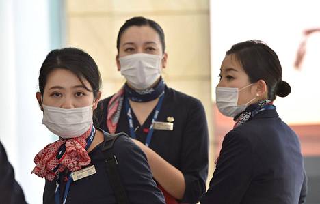 China Eastern Airlines -yhtiön lentoemännät olivat varustautuneet suusuojin Shanghaista lähteneen koneen laskeuduttua Sydneyn lentokentälle Australiassa lauantaina.