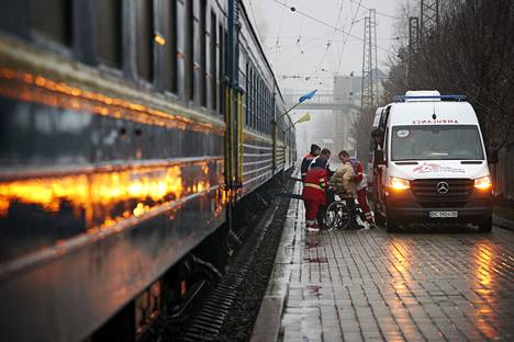 Огни карет скорой помощи и синие вагоны поезда “нарисовали” на составе украинский флаг. Фото: Юха Салминен / HS