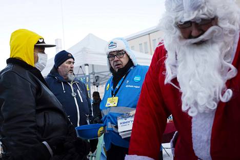 Perussuomalaisten aluevaaliehdokas Kari Mattila (keskellä) jakoi muovikauhasta vaalimakeisia Tikkurilan joulutorilla lauantaina.