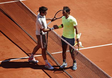 Roger Federer (vas.) onnitteli Rafael Nadalia voitosta ja loppuotteluun etenemisestä.