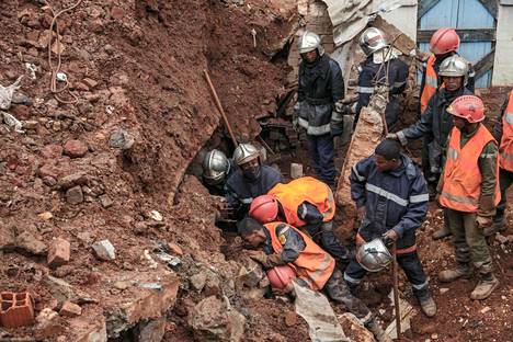 Pelastustyöntekijät etsivät eloonjääneitä myrskyn takia tuhoutuneista rakennuksista Antananarivossa maanantaina.