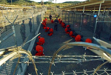Vangit oransseissa haalareissa istuivat sotilaspoliisin valvonnassa Guantanamon sotilastukikohdassa tammikuussa 2002.