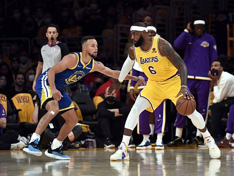 Golden Staten Stephen Curry puolusti Lakersin LeBron Jamesia NBA-kauden avausottelussa.
