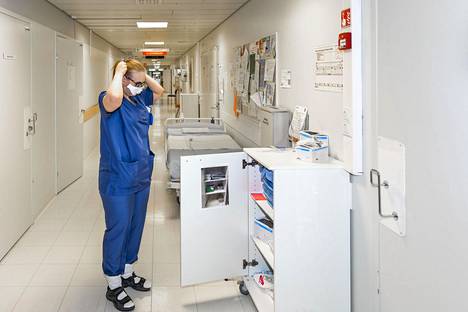 Koronapotilaiden osastolla työskentelevä sairaanhoitaja pukee ylleen suojavarusteita Oulun yliopistollisessa sairaalassa. Sairaanhoitajaliiton kyselyn mukaan moni hoitaja kokee esimerkiksi virukseen liittyvän suojapukeutumisen sekavaksi.