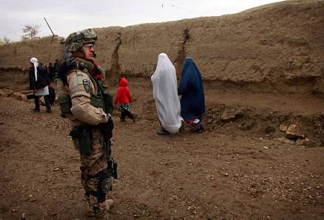 Naiset kulkivat kylänraittia, kun suomalainen rauhanturvaaja tarkkaili tilannetta Charar Bolakin piirikunnassa Pohjois-Afganistanissa 2011. 