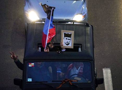 Ihmiset heiluttivat Donetskin "kansantasavallan" lippua ja Vladimir Putinin kuvaa autosta mielenosoituksessa Venäjän puolesta Serbian pääkaupungissa Belgradissa viime lauantaina.