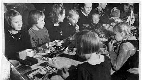 Saksalaiset järjestivät joulupöydän sotaorvoille Rovaniemellä 1942. Taisto Oikkonen on sylissä istuva pieni poika.
