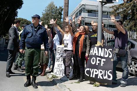 Ihmiset osoittivat mieltään Kyproksen presidentin Nicos Anastasiadesin saattueen ajaessa parlamenttitalolle Nikosiassa maanantaina.
