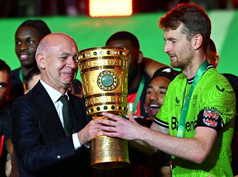 Football boss Bernd Neundorf handed the trophy to the Finnish captain.