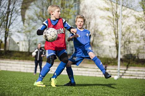 HJK:n 10-vuotiaat jalkapallojuniorit Ukko Kellokoski (vas.) ja Joel Salomaa taistelivat pallosta Saharan kentällä Töölössä vuonna 2014.