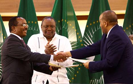 Etiopian hallinnon edustaja Redwan Hussien (vas.) ja Tigrayn edustaja Getachew Reda (oik.) kättelivät aselevon merkiksi Etelä-Afrikan Pretoriassa marraskuussa. Keskellä Kenian entinen presidentti Uhuru Kenyatta.
