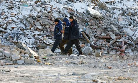 Miehet kävelivät iskussa tuhoutuneen rakennuksen vieressä 10. tammikuuta. 