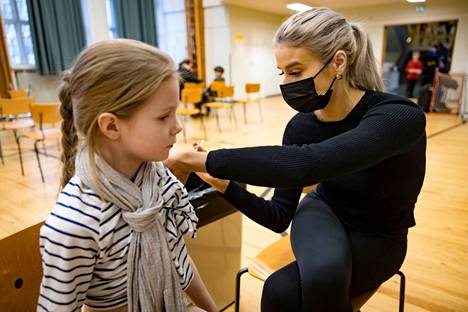 Käpylän peruskoulun tokaluokkalainen Elisa Palmu sai koronarokotuksen koulussa terveydenhoitaja Alina Saukolta. Jatkossa joukkorokotuksia ei enää järjestetä kouluilla.