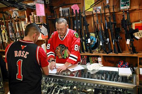 Phil Flores esittelee asiakkaalle pistoolia urheilukaupassa Tinley Parkissa Illinoisissa.
