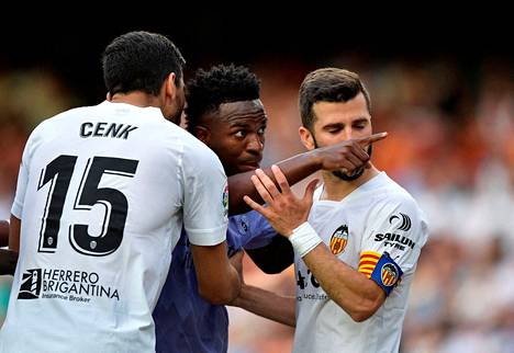 Real Madridin Vinicius Junior osoitti kohti faneja samalla, kun Valencian Jose Gaya ja Cenk Ozkacar yrittivät rauhoitella häntä. 