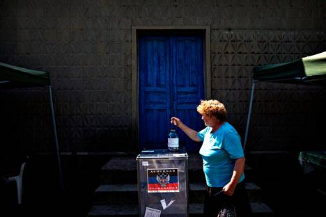 Nainen pudotti äänestyslipun Kurahovkan kerhohuoneen edustalla Donetskin länsipuolella ”kansanäänestyksessä” toukokuussa 2014.