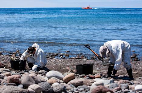 Miehet keräsivät venäläisaluksesta vuotanutta öljyä Venegueran rannalla Gran Canarian saarella.