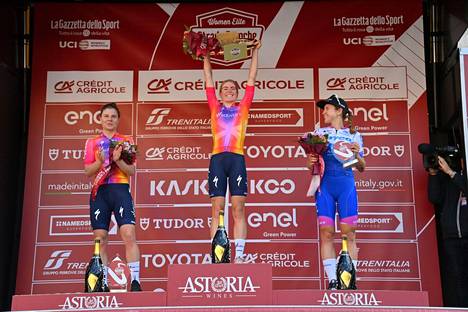 Tässä vaiheessa kaikki oli vielä hyvin. Kristen Faulkner (oik.) hymyili Strade Bianche -kilpailun palkintokorokkeella voittaja Demi Wolleringin ja toiseksi sijoittuneen Lotte Kopeckyn (vas.) kanssa.