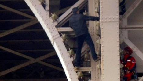 Eiffel-torni evakuoitiin kiipeilevän miehen takia, pelastusmiehet yrittävät taivutella häntä turvaan korkeuksista