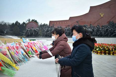 Ihmiset laskivat kukkia Pohjois-Korean perustajan Kim Il-sungin ja hänen seuraajansa Kim Jong-ilin patsaiden juurelle Pjongjangissa sunnuntaina.