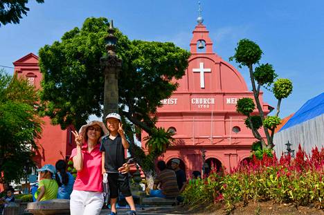 Turistit poseerasivat Malesian Melakassa sijaitsevan katolisen kirkon edustalla kesällä 2013.
