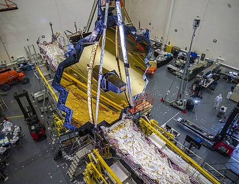 James Webb -avaruusteleskooppia testattiin vielä maan päällä joulukuussa. Hopeanväriset osat eli lämpösuojat levitettiin auki avaruudessa. Ne saatiin kireiksi tiistaina. Seuraavaksi nostetaan ylös pelit. Kuvassa pääpeili on jo ylhäällä testeissä. 
