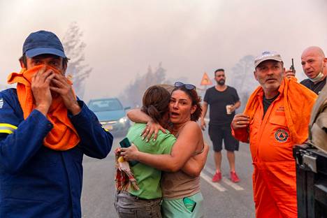 Local residents consoled each other after a wildfire raged near the village of Varnávas on Sunday.