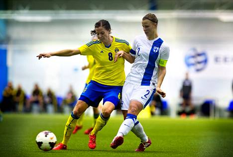 Suomen Maija Saari yritti pysäyttää Ruotsin tähtipelaajan Lotta Schelinin, kun joukkueet kohtasivat 2015.