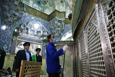 Terveystyöntekijä desinfioi shiialaisille tärkeän imaami Rezan siskon Fatiman hautaa mausoleumimoskeijassa Qomin kaupungissa Iranissa helmikuun lopussa.