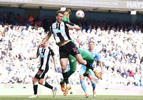 Newcastlen Dan Burn taistelee Manchester Cityn maalivahtia Edersoia vastaan Valioliigan ottelussa toukokuussa.