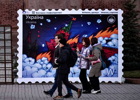 Teos Kiovassa kadulla esittää postimerkkiä, jossa Kreml palaa. 