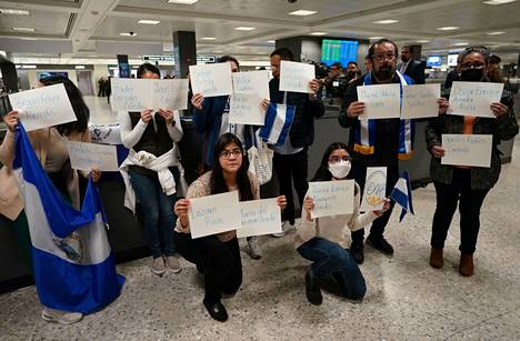 Aktivistit pitelivät lentokentällä nimikylttejä vapautetuille vangeille.