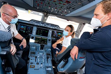 Tokion-lennon kapteeni Ari Huusela esittelee A350-koneen ohjaamoa Sinem Kurtbaylle ja Akseli Keskiselle.