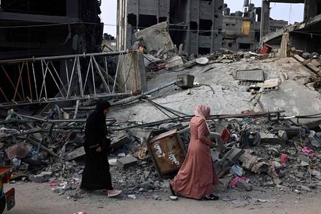 Pedestrians pass a destroyed building in Rafah, southern Gaza.