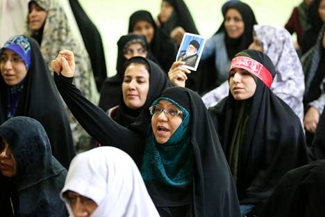 Ihmiset kuuntelivat ajatollah Ahmad Khatamin perjantaisaarnaa ja huusivat iskulauseita Teheranissa. Jotkut pitelivät Iranin korkeimman johtajan, suurajatollah Ali Khamenein kuvia.