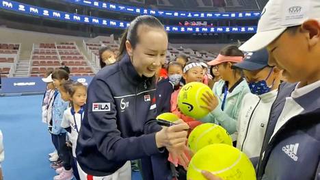 Tennistähti Peng Shuai näyttäytyi marraskuussa 2021 lasten tennisturnauksessa ja signeerasi tennispalloja. Kuva videosta Twitter-viestissä.