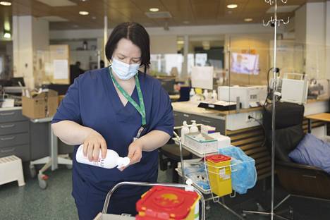 Sairaanhoitaja Satu Helminen hoitaa syöpäpotilaita ja valmistautuu laittamaan kanylointivälineitä kuntoon.