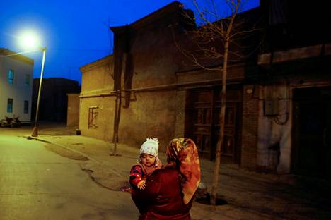 Uiguurinainen kantoi lastaan Kashgarin vanhassakaupungissa Xinjiangissa maaliskuussa 2017.
