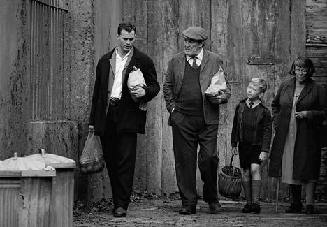 Belfast on mustavalkoinen elokuva, mutta Kenneth Brnagh pelaa myös väreillä tuodessaan kuviin nyky-Belfastin. Jamie Dornan (vas.) näyttelee Pan roolin, Ciarán Hinds on Pop, Jude Hill Buddy ja Judi Dench Granny. 