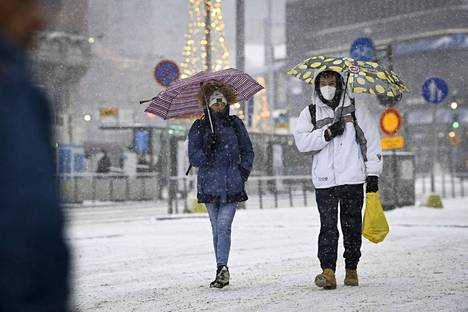Tiistaina pääkaupunkiseudulle on luvassa märkää lunta, räntää tai jopa vesisadetta. Kuvassa ihmisiä Helsingissä joulukuussa.